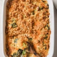 Broccoli casserole with a wooden spoon on a baking dish.
