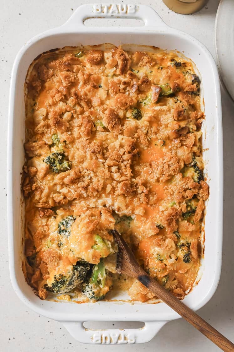 Broccoli casserole with a wooden spoon on a baking dish.