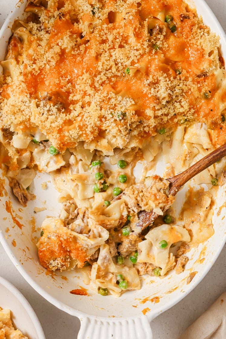 Easy tuna noodle casserole with a wooden spoon in a baking dish.