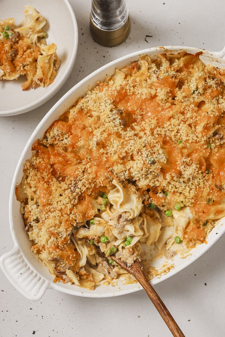 Easy tuna noodle casserole with a wooden spoon in a baking dish.
