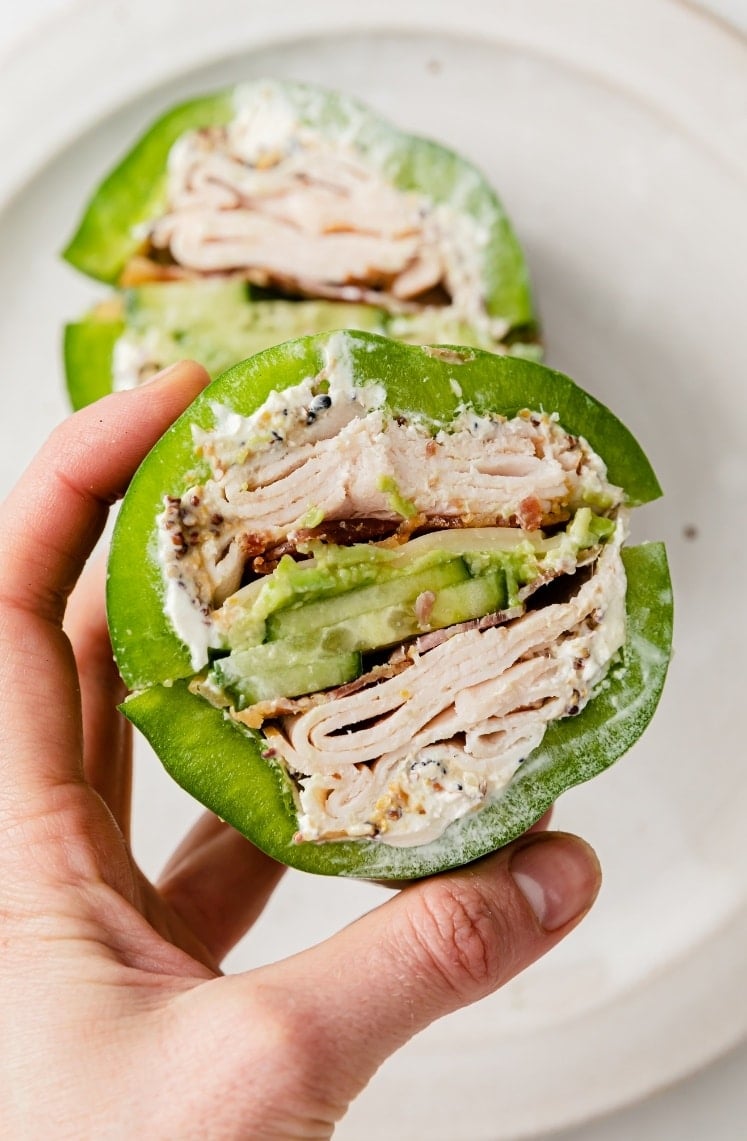 A hand holding a bell pepper sandwich.