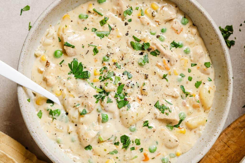 Chicken chowder in a bowl with a spoon.