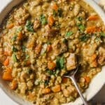 Slow cooker split pea soup in a bowl with a spoon.