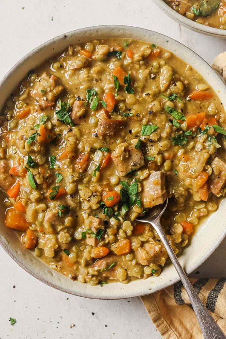 Slow cooker split pea soup in a bowl with a spoon.