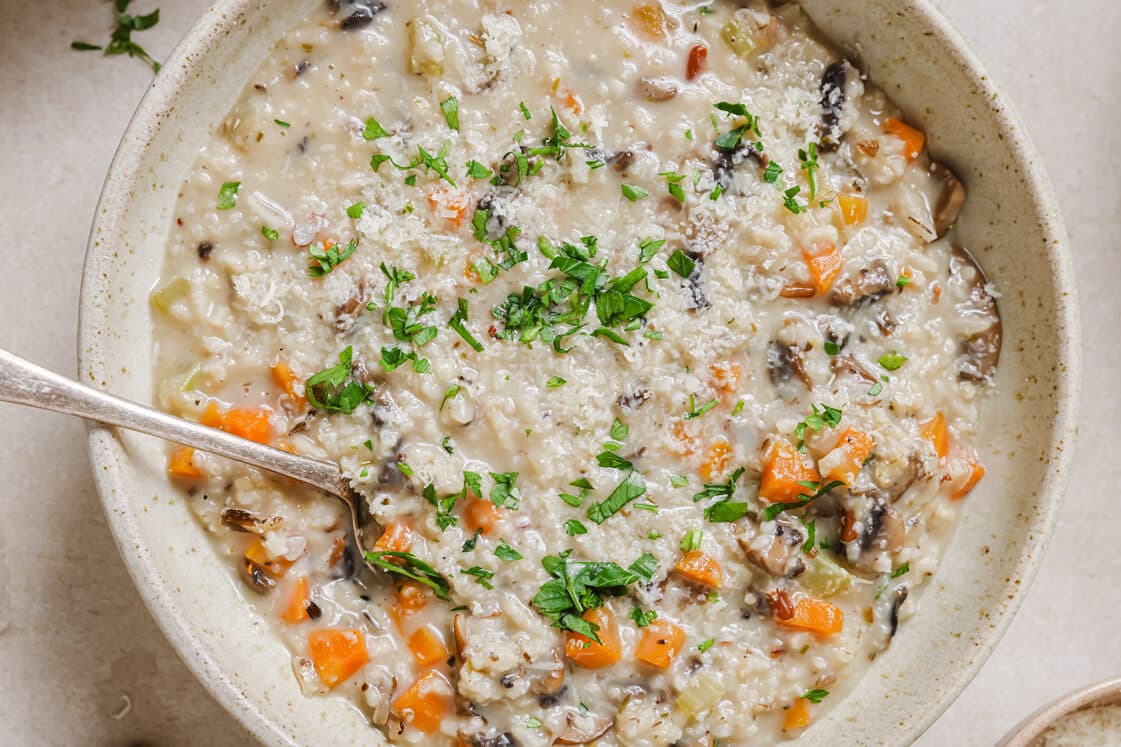 A bowl of wild rice mushroom soup with a spoon.