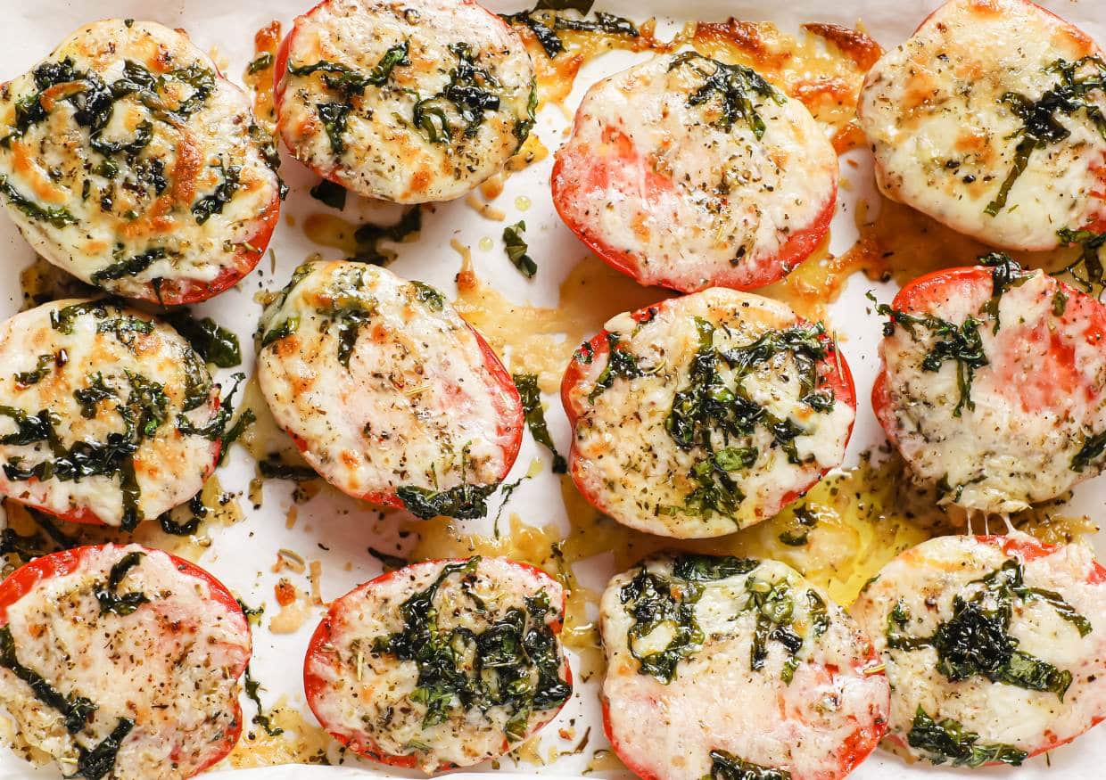 Baked tomatoes with Parmesan and mozzarella cheese garnished with parsley.