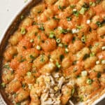 Chicken tater tot casserole with a spoon in a casserole dish.