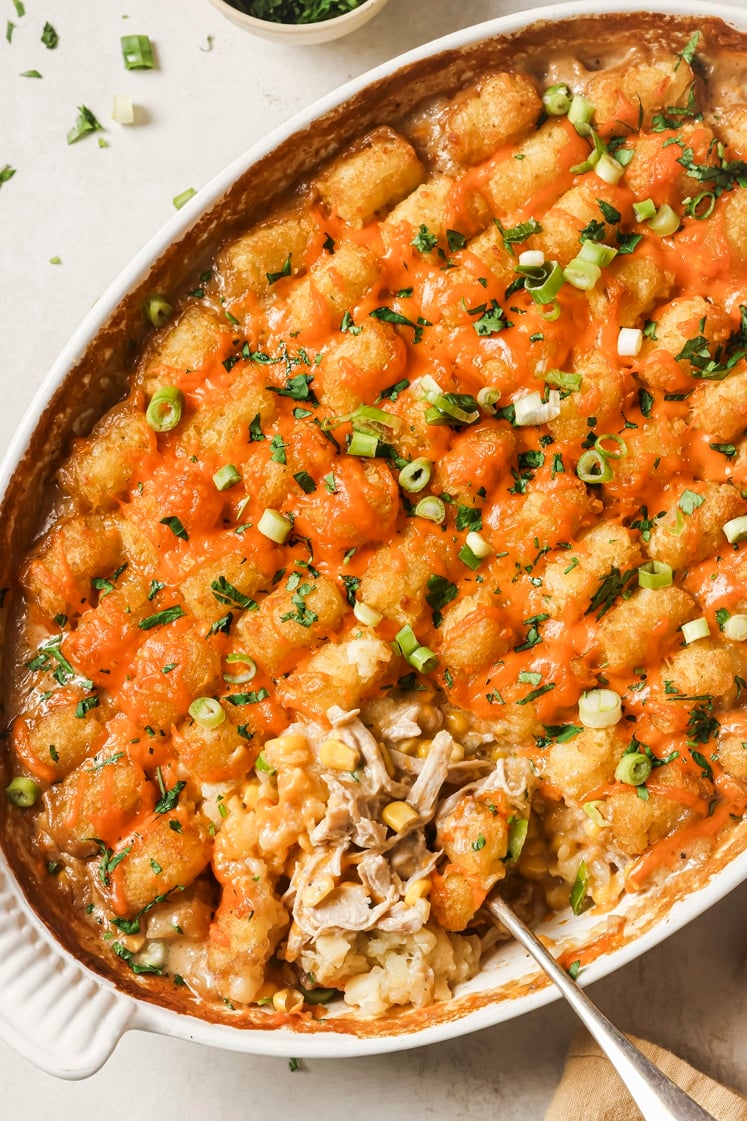 Chicken tater tot casserole with a spoon in a casserole dish.