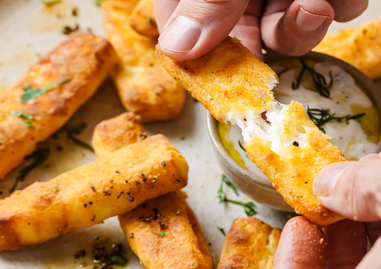 Halloumi fries with dill dip on a plate.