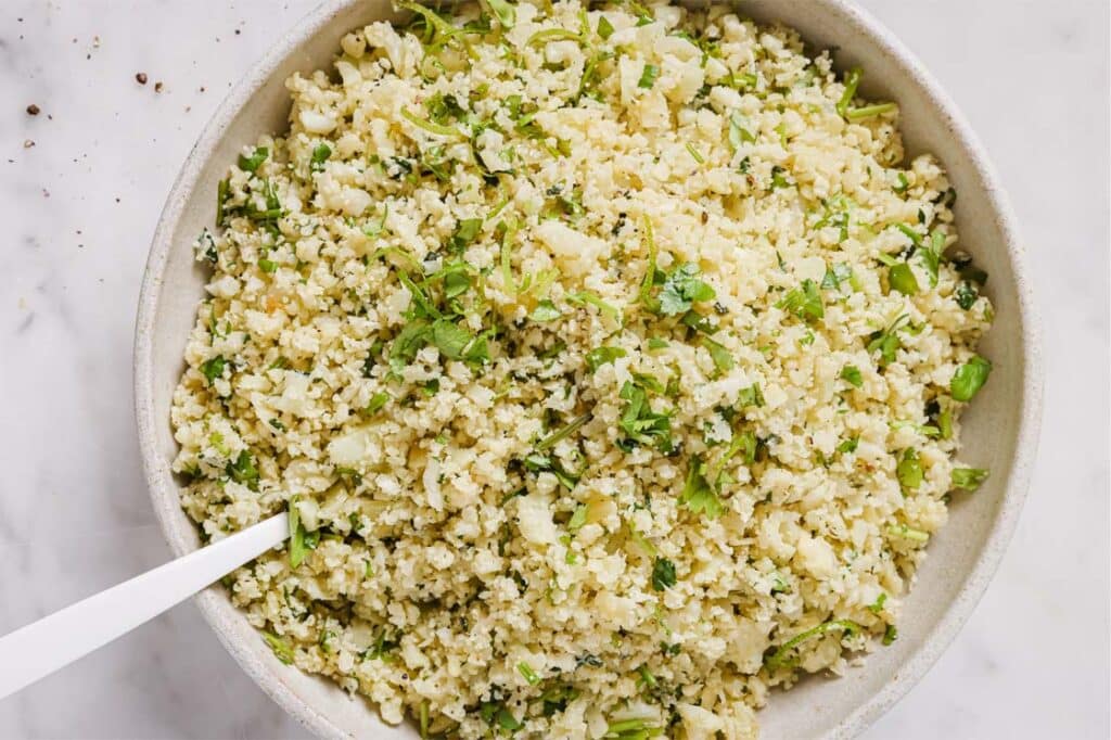 Cilantro lime cauliflower rice in a bowl with a spoon.