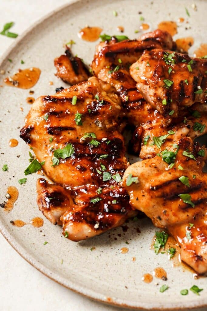 Garnished grilled hot honey chicken on a plate.