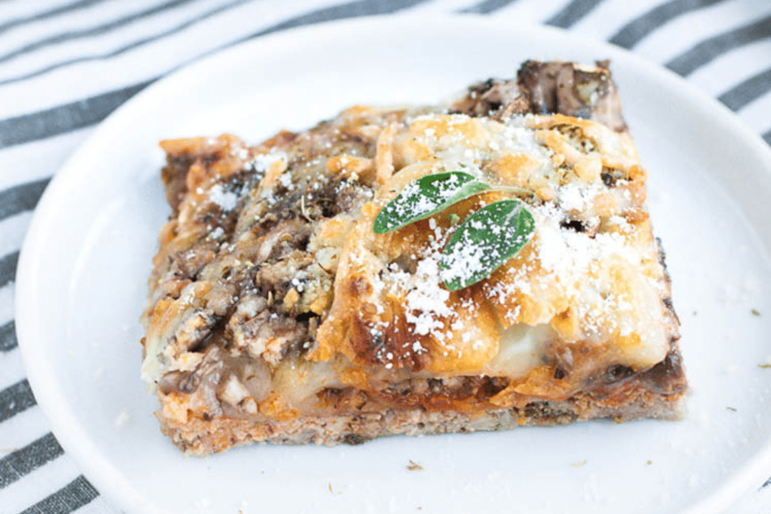A pizza with meat and sauce on a plate.