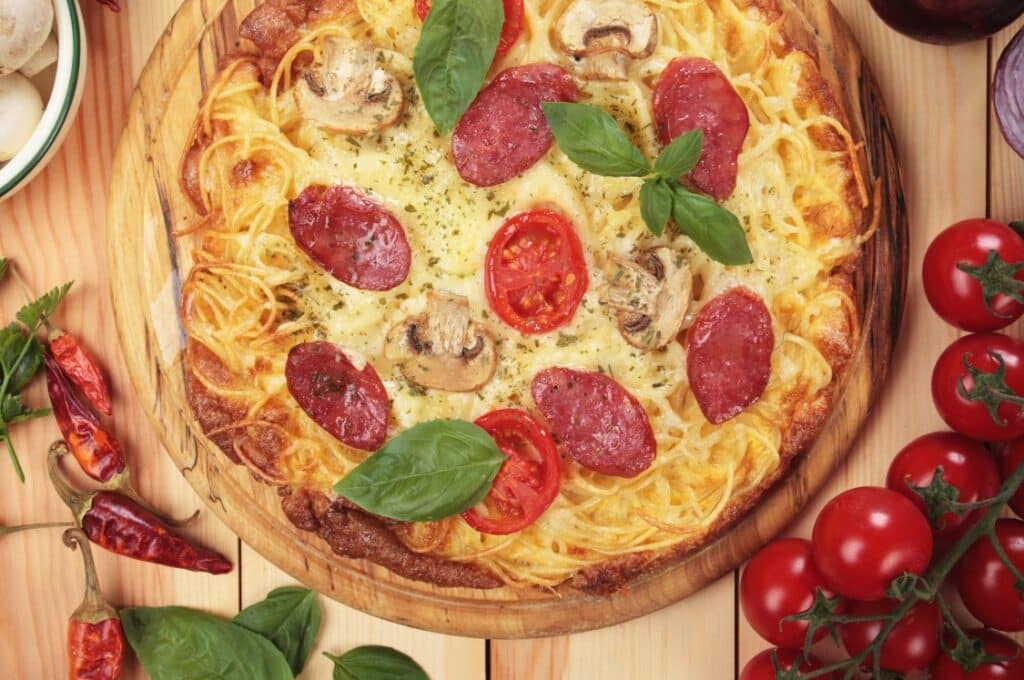 Spaghetti noodles on a pizza.