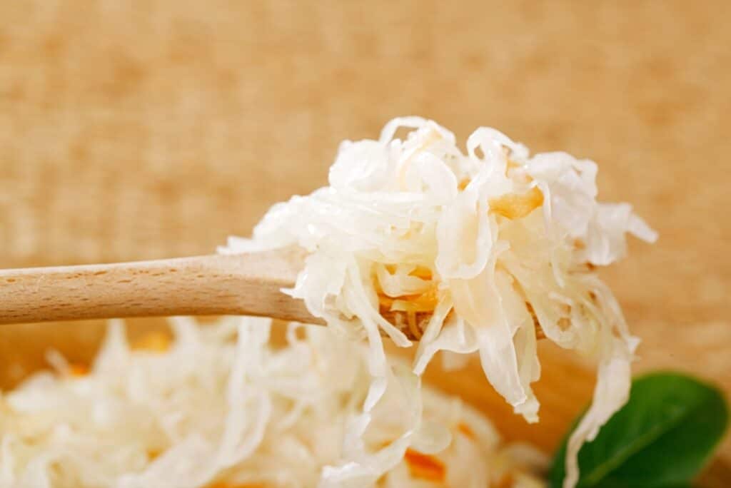 Sauerkraut on a wooden spoon.