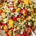 Fresh corn salad on a plate with a spoon.