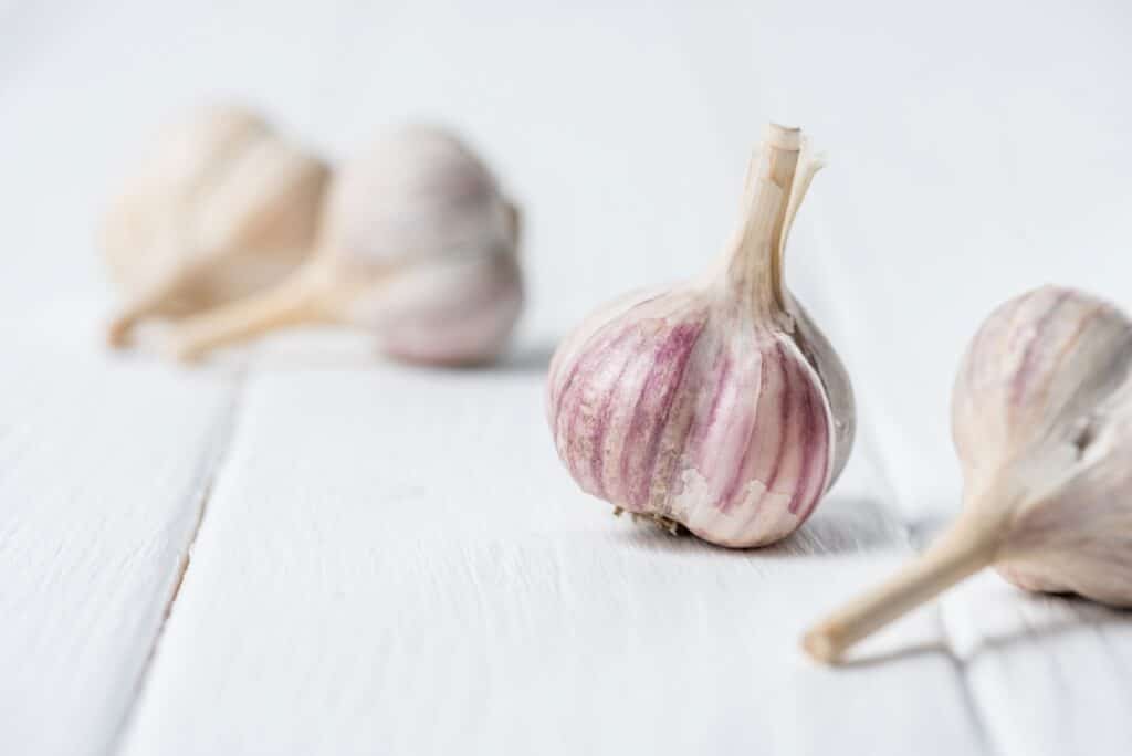 Fresh garlic on a white wooden table.