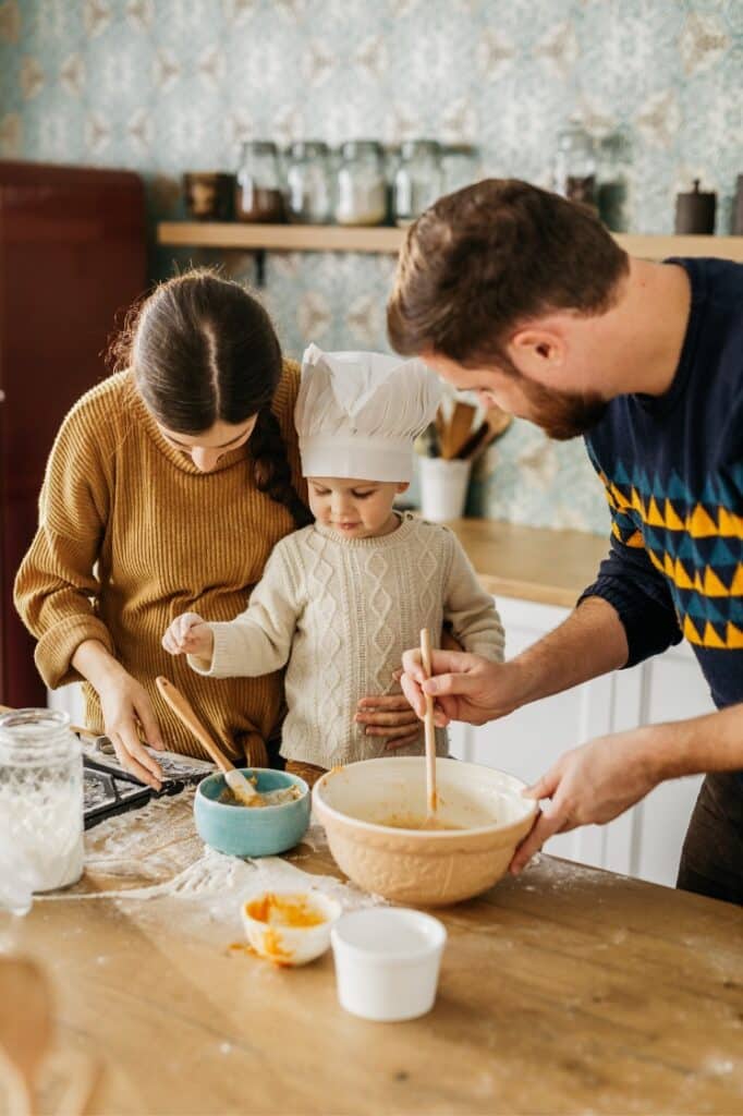 Parents cooking with their kid.