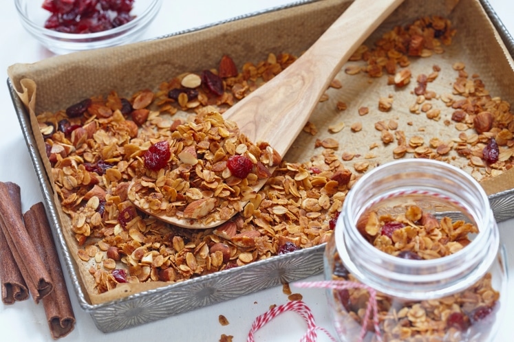 Granola in a pan with a serving spoon.