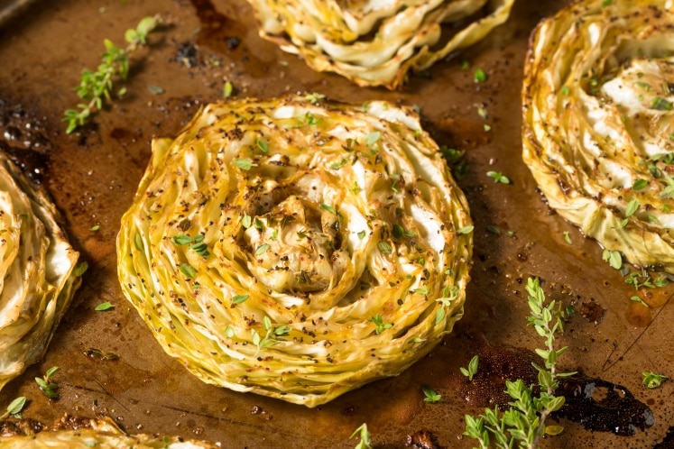 Cabbage steaks garnished with herbs.