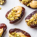 Dates stuffed with peanut butter and crushed pistachios.