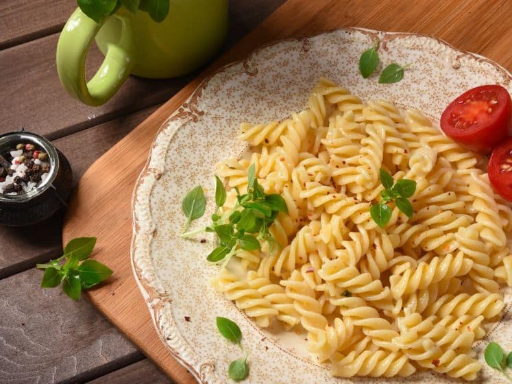 Fusilli pasta on a plate. Rustic wooden table.