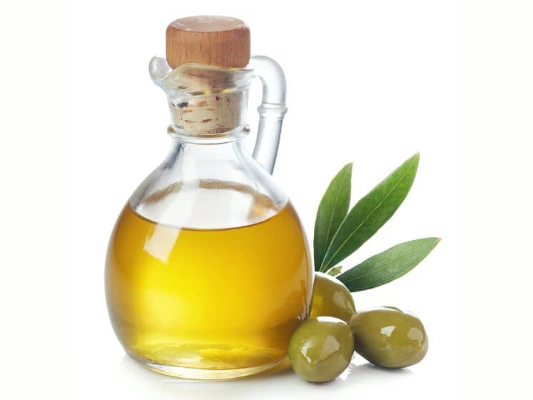 Bottle of fresh extra virgin olive oil and green olives with leaves