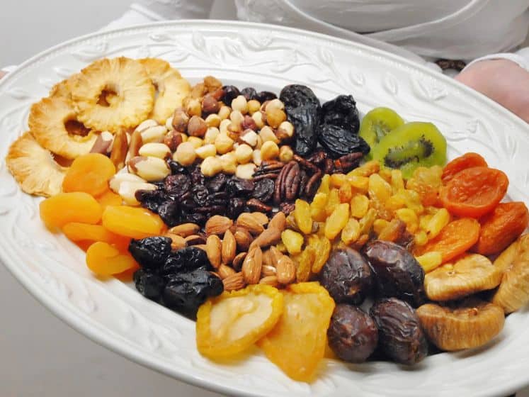 A selection of dried fruit and nuts on a white platter