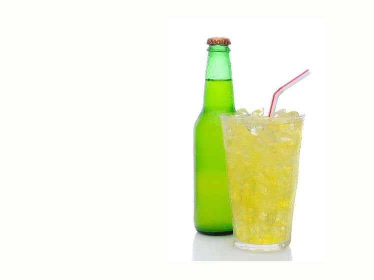 Glass of soda with drinking straw and bottle