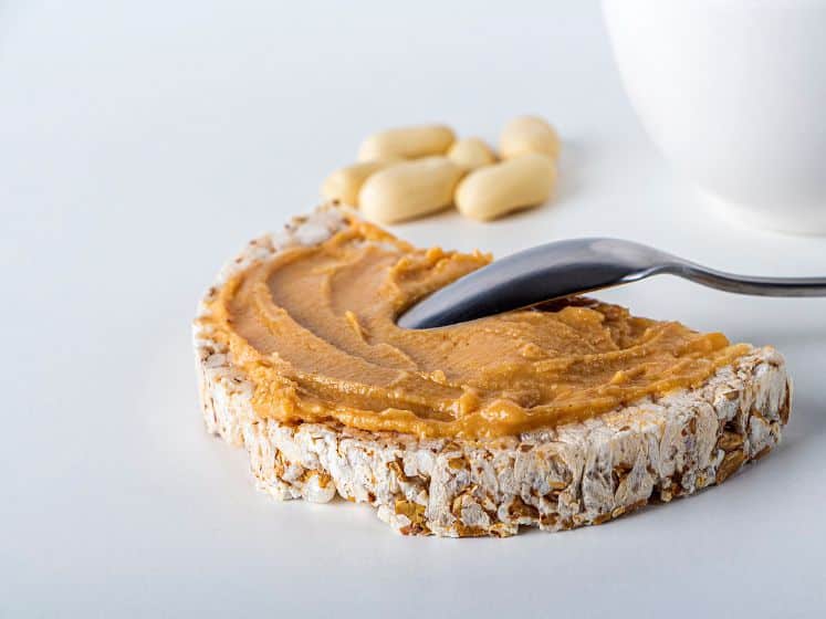 Rice cakes with homemade creamy peanut butter or paste white background