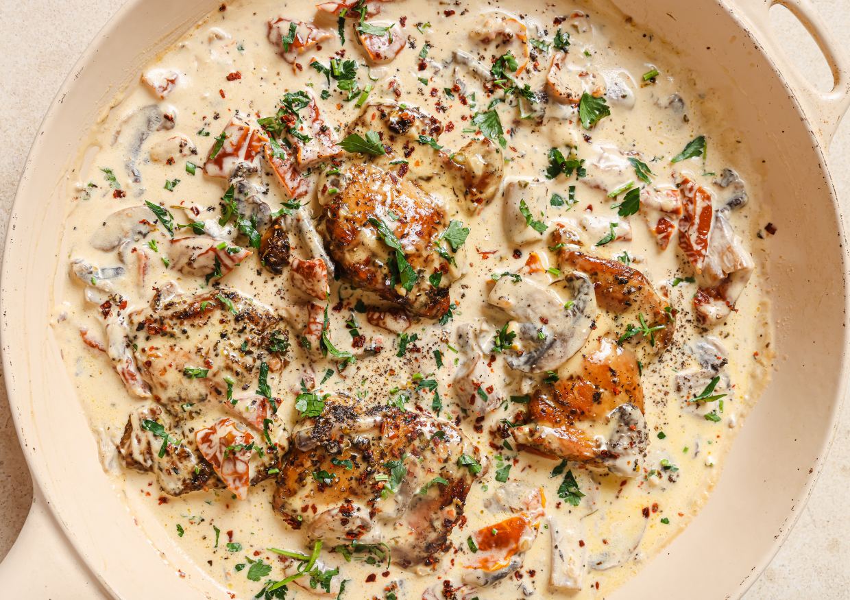 Chicken with creamy mushroom sauce in a pan.