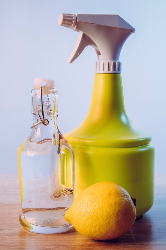 Vinegar, lemon and plastic spray bottle.