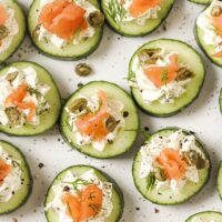 Garnished cucumber and dill smoked salmon appetizer on a plate.