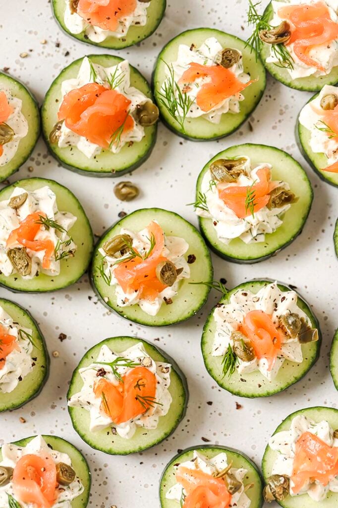 Garnished cucumber and dill smoked salmon appetizer on a plate.