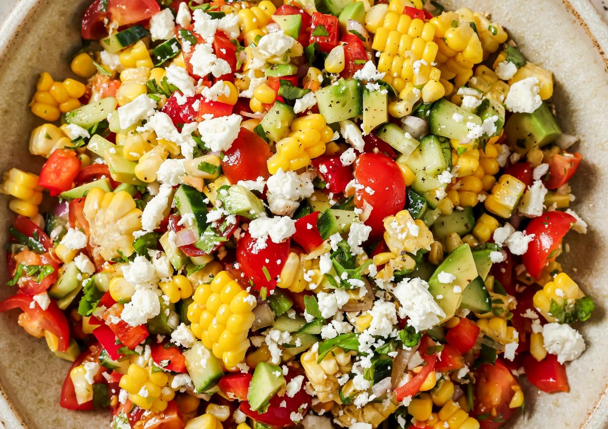 Fresh corn salad with feta crumbles in a bowl.