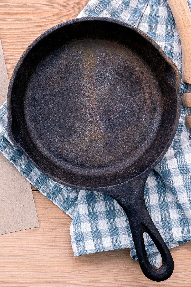Rusted cast iron skillet on a dish towel.