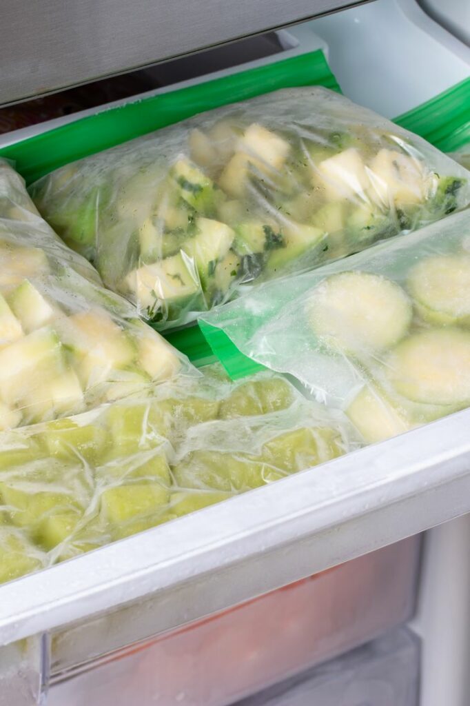 Frozen zucchini cubes and slices in freezer bags.