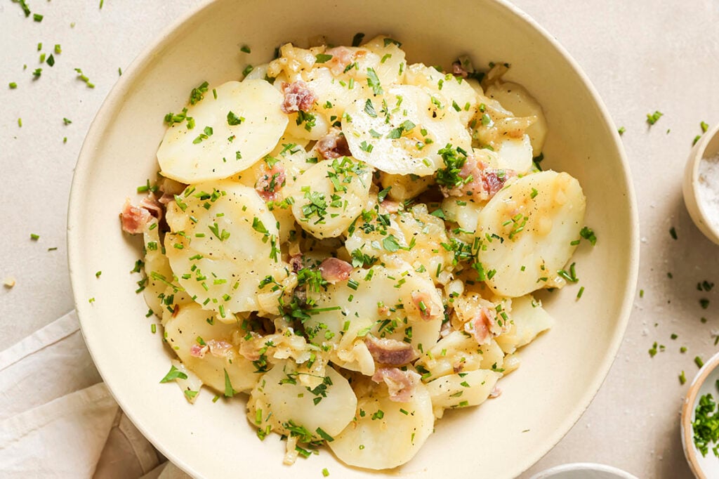 Garnished German potato salad in a bowl.