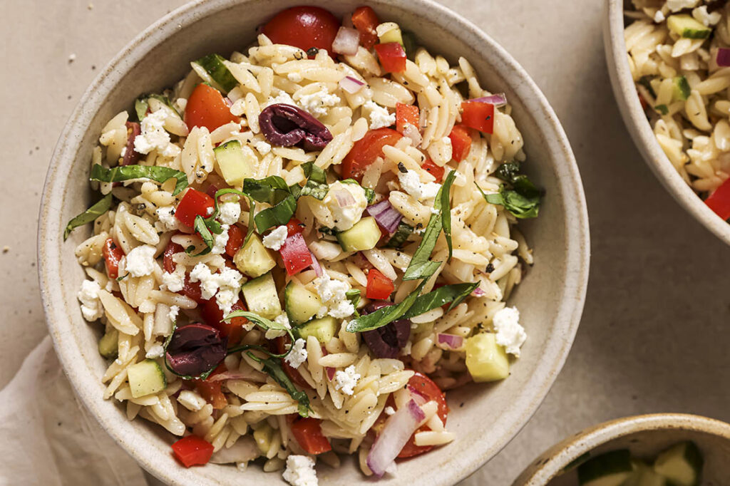 Garnished Italian orzo pasta salad in bowls.