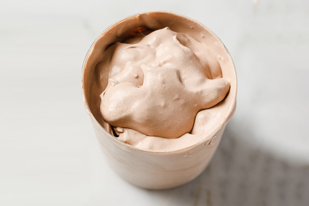 A glass of a keto frosty on a marble countertop.