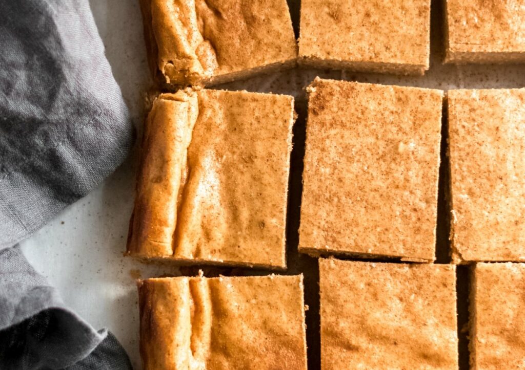 Keto pumpkin cheesecake bars on a countertop.