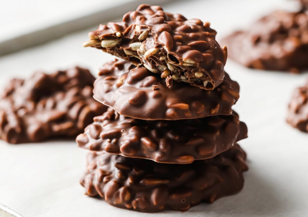 A stack of low-carb milk chocolate sunflower seed clusters with one cut in half.