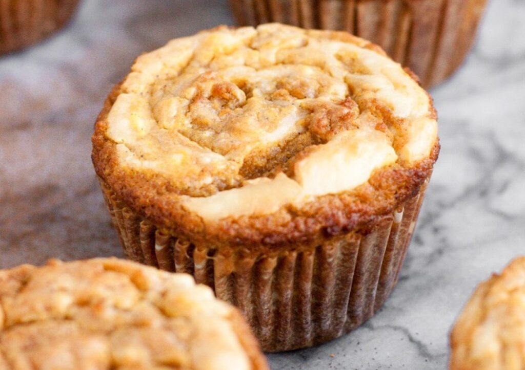 Low-carb cream cheese pumpkin muffins on a marble countertop.