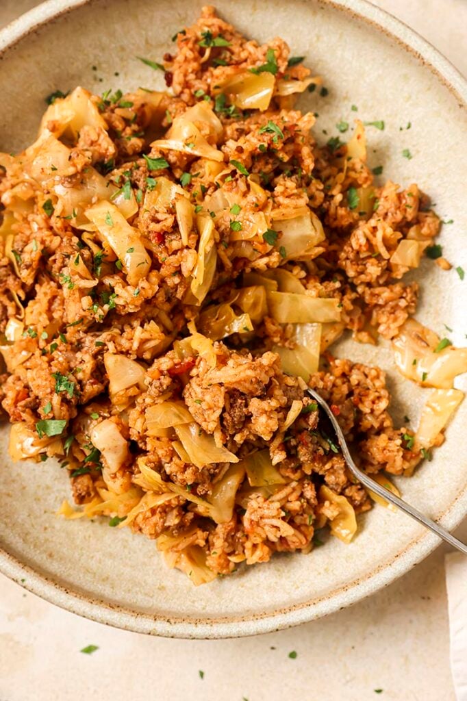 A plate of unstuffed cabbage rolls with a fork.