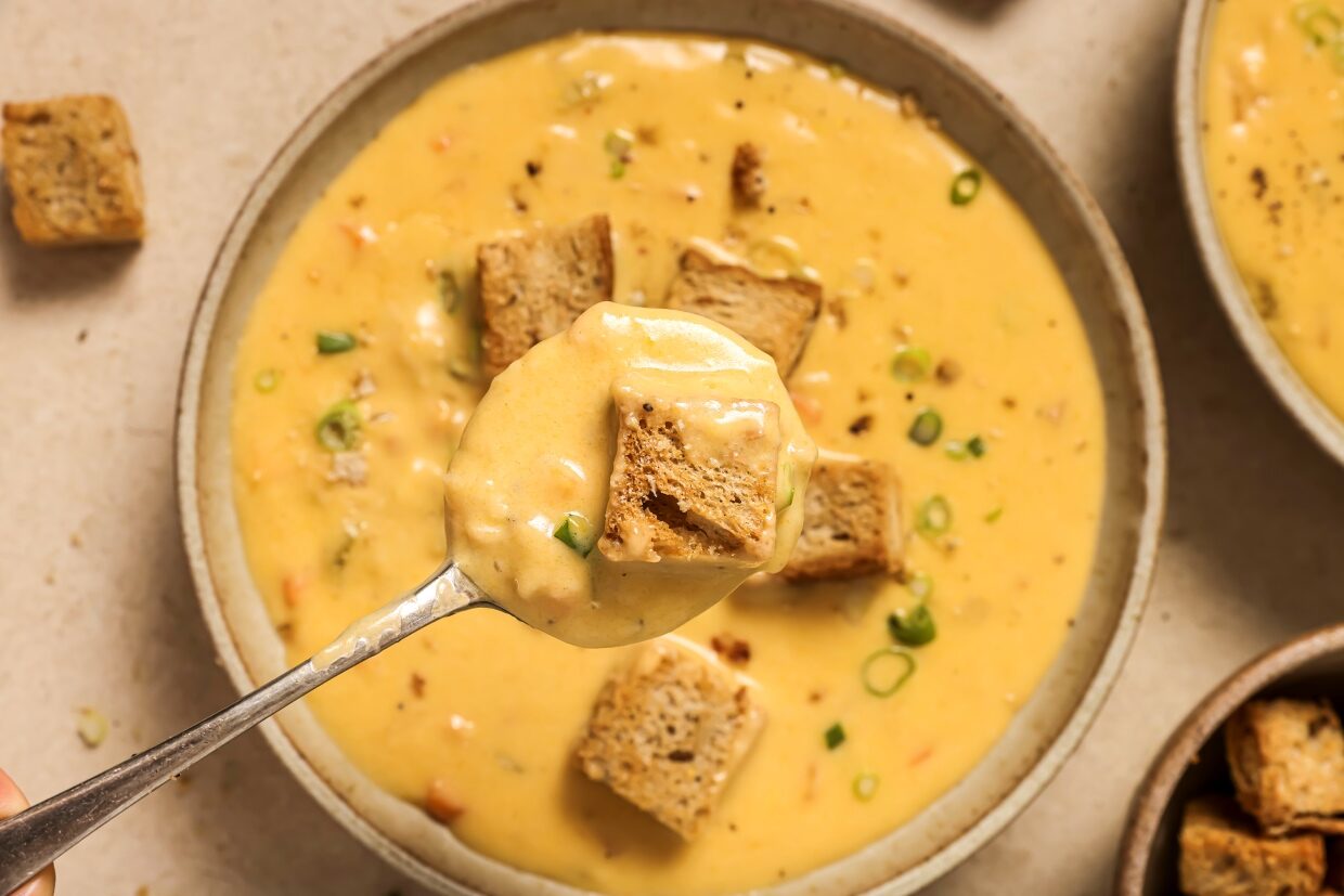 A bowl of Wisconsin beer cheese soup with croutons and chives.