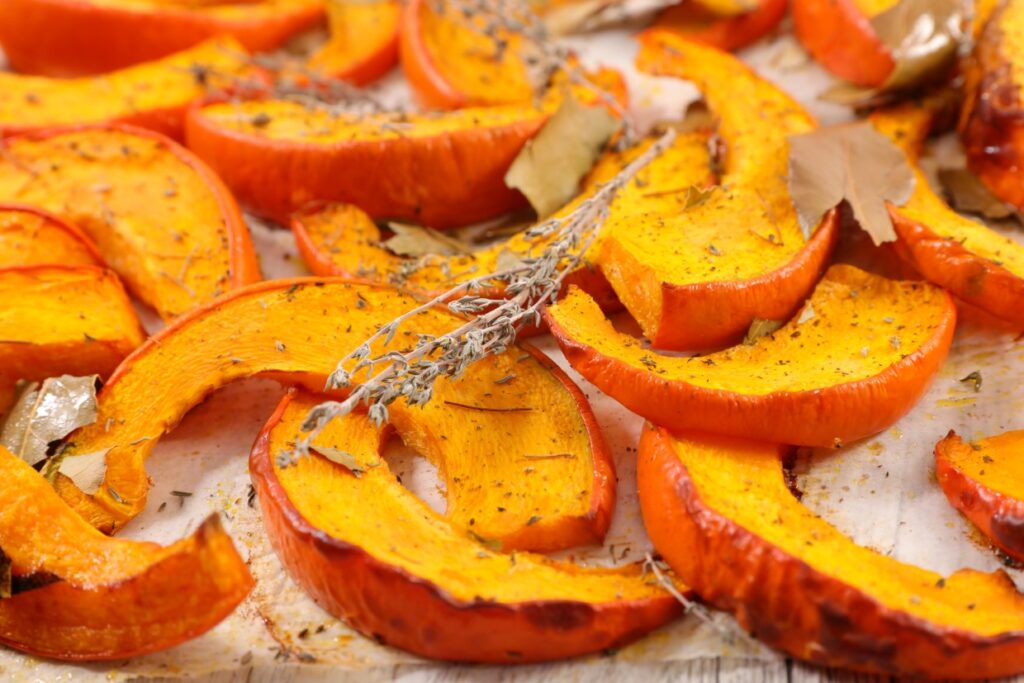 Baked pumpkin slices on parchment paper.