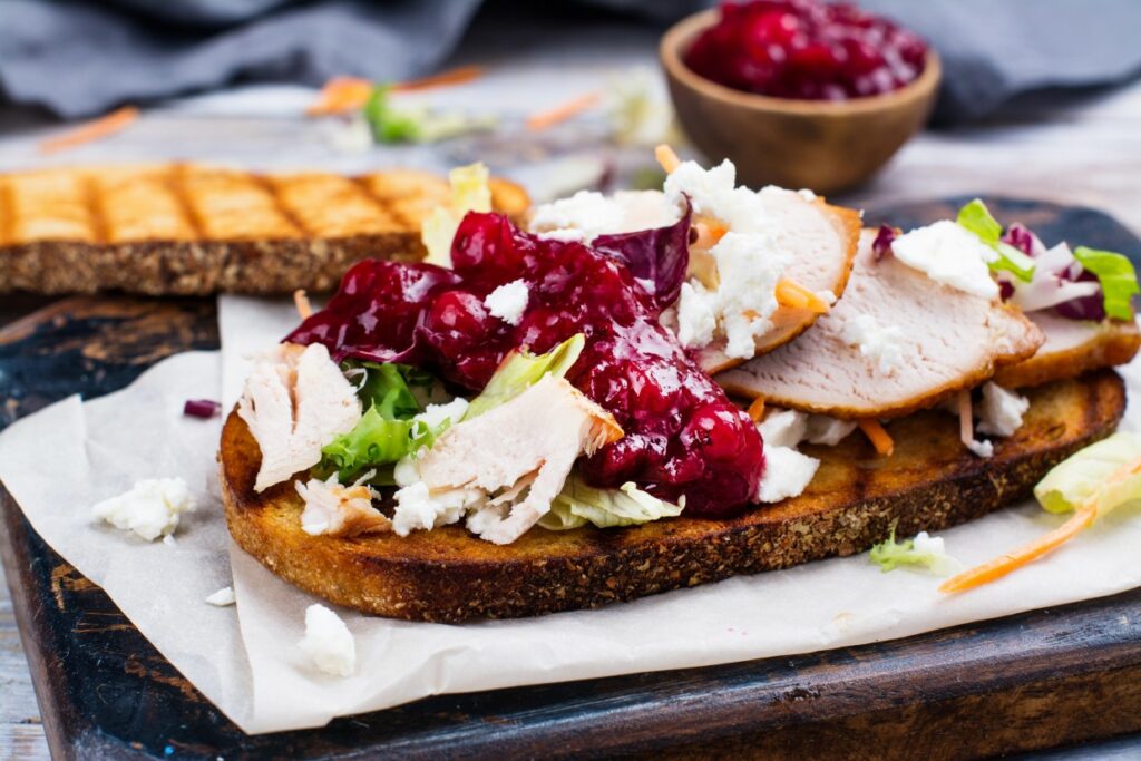 A turkey sandwich with cranberry sauce.