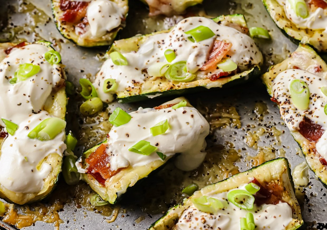 Three loaded zucchini boats on a plate.