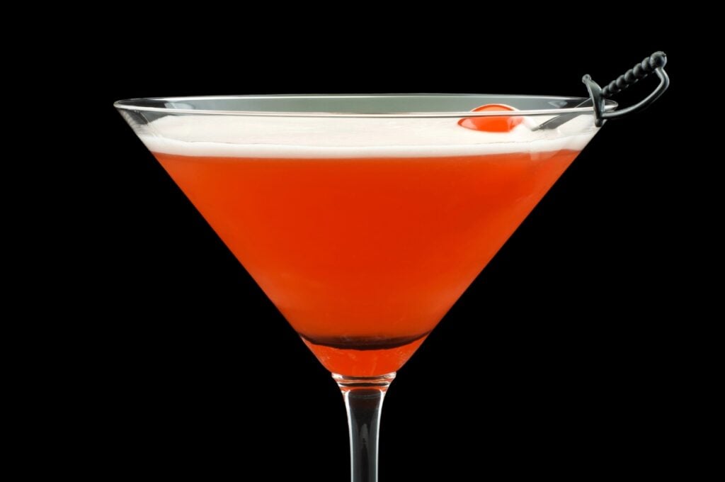 Mary Pickford cocktail with a cherry skewered.