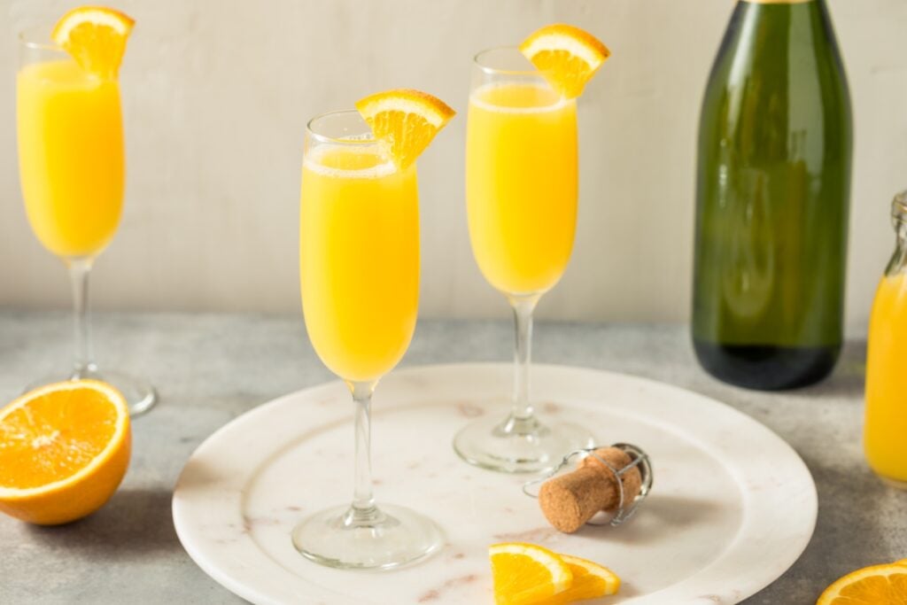 Mimosa cocktails near a champagne bottle.