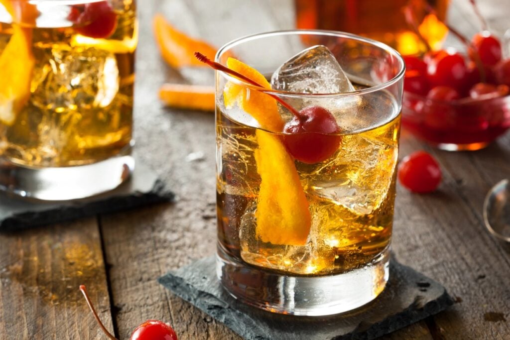 Old Fashioned cocktail with an orange slice and a cherry.